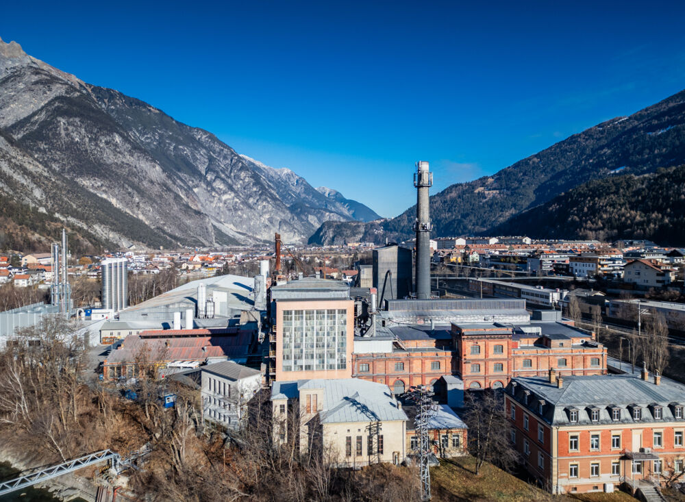 Großes Industriegelände mit Produktionsgebäuden und Schornsteinen, das die Entstehung industrieller CO₂-Ströme veranschaulicht