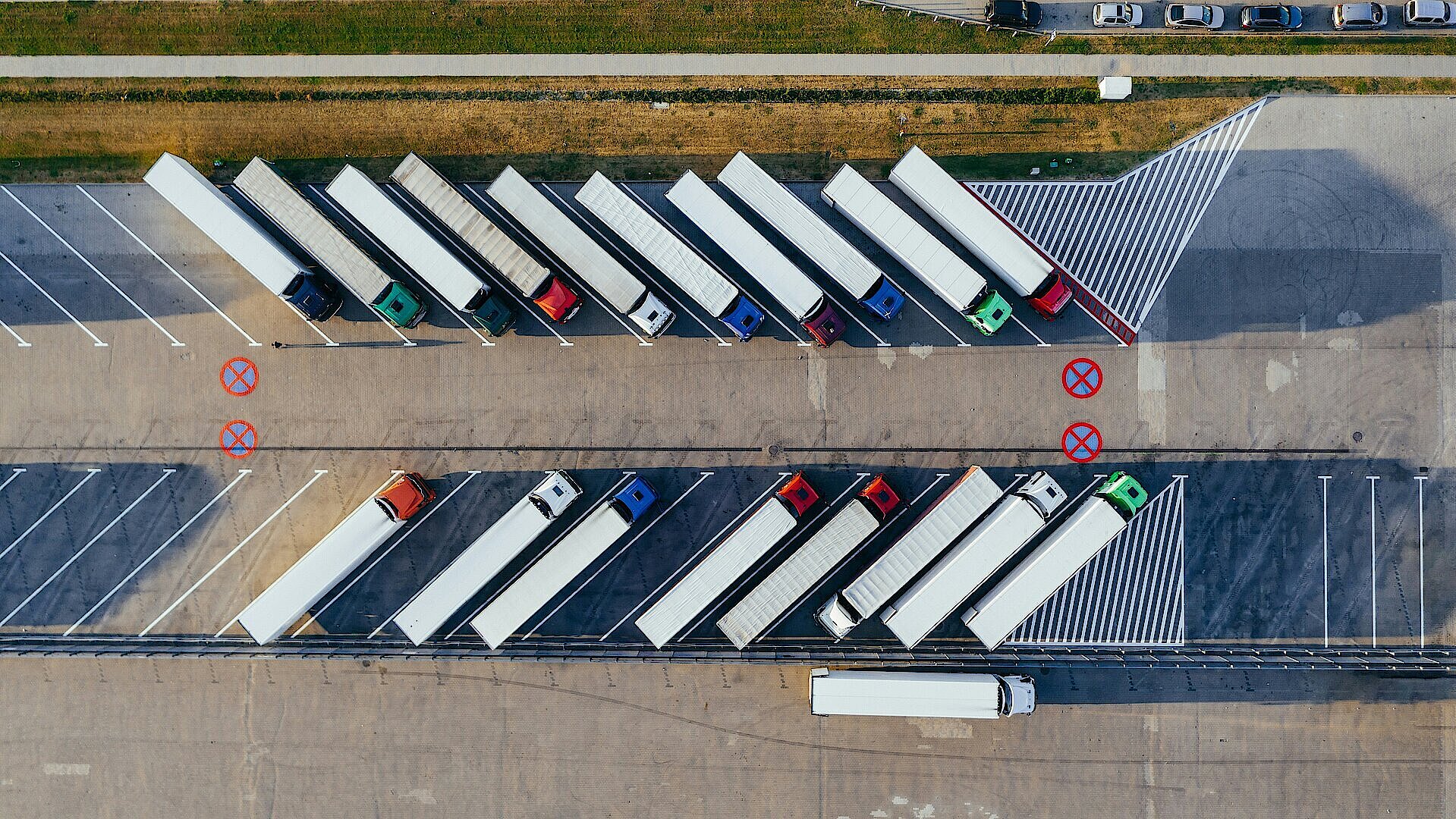 Luftaufnahmen von LKWs auf einem Rasthof die aneinandergereiht parken