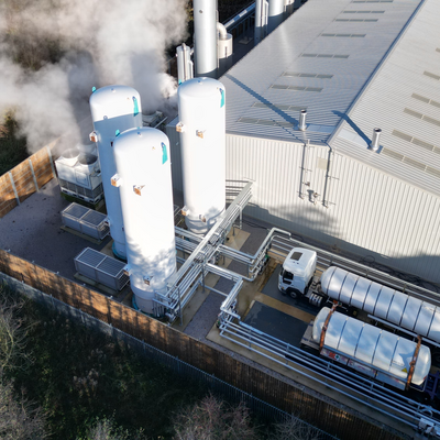 The image shows an industrial CO₂ recovery plant with storage and loading infrastructure. The image illustrates the recovery, storage and provision of CO₂ for further processing and industrial applications.